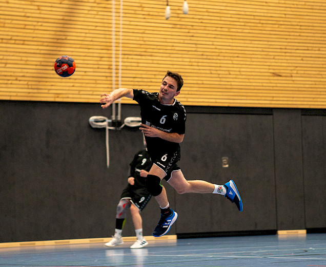 Daniel Rosemeyer wirft springend beim Handballspiel den Ball in Richtung Tor