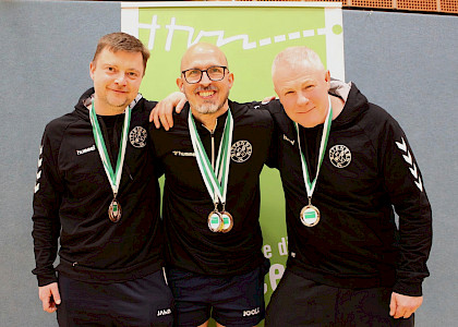 drei Tischtennisspieler mit ihren Medaillen