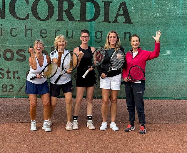 Tennisdamen, die nach ihrem Sieg nebeneinander stehen, denSchläger halten und eine Siegespose machen mit einer hochgestreckten Faust oder Hand Tennisdamen, die nach ihrem Sieg nebeneinander stehen, denSchläger halten und eine Siegespose machen mit einer hochgestreckten Faust oder Hand