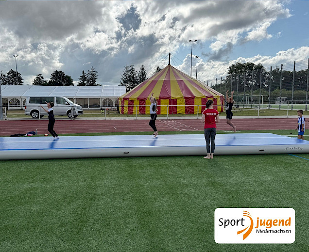Kinder beim Turnen auf der Bodenmatte mit Luft, dem Airtrack