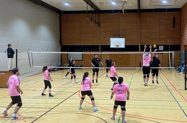 unsere Volleyballmannschaft in rosa Trikots spielen gegen eine andere Mannschaft unsere Volleyballmannschaft in rosa Trikots spielen gegen eine andere Mannschaft