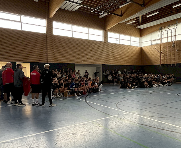 Elternabend in der Sporthalle mit vielen Eltern und Spielern, die auf den Bänken und auf der Tribüne sitzen