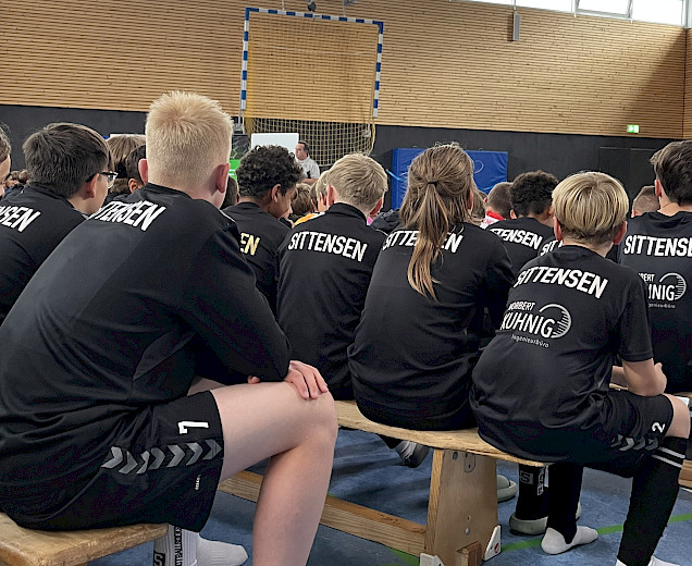 Spieler beim Elternabend von hinten fotografiert, die auf den Bänken sitzen