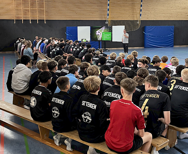 Elternabend in der Sporthalle mit vielen Eltern und Spielern, die auf den Bänken und auf der Tribüne sitzen