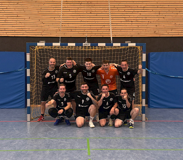 die Handballherren haben sich in ihrem Tor zum Mannschaftsfoto aufgebaut