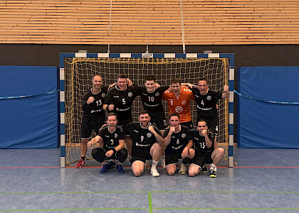 die Handballherren haben sich in ihrem Tor zum Mannschaftsfoto aufgebaut