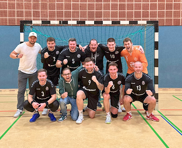 Handballherren im Tor zum Gruppenfoto aufgestellt nach ihrem Heimsieg, sie freuen sich und lachen