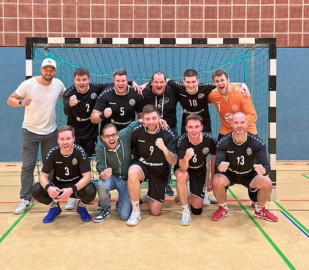 Handballherren im Tor zum Gruppenfoto aufgestellt nach ihrem Heimsieg, sie freuen sich und lachen