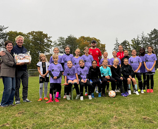 die Mädchen der E-Juniorinnen stehen mit den Trainern und den Sponsoren aufgestellt auf dem Platz und überreichen einen großen Präsentkorb die Mädchen der E-Juniorinnen stehen mit den Trainern und den Sponsoren aufgestellt auf dem Platz und überreichen einen großen Präsentkorb