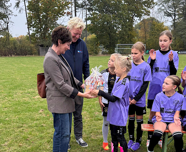 die Mädchen der E-Juniorinnen stehen mit den Trainern und den Sponsoren aufgestellt auf dem Platz und überreichen einen großen Präsentkorb die Mädchen der E-Juniorinnen stehen mit den Trainern und den Sponsoren aufgestellt auf dem Platz und überreichen einen großen Präsentkorb
