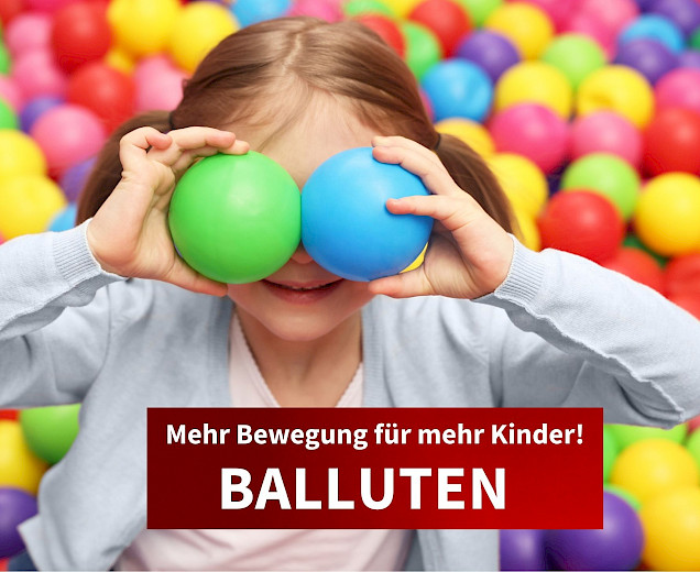 kind im bällebad mit zwei kleinen bällen vor den augen