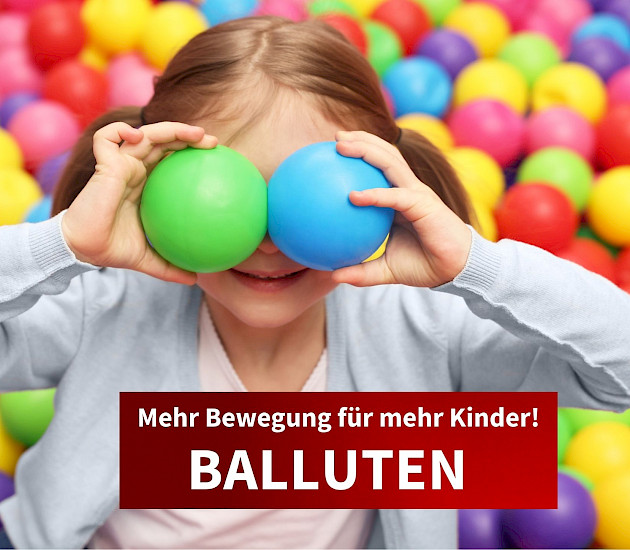kind im bällebad mit zwei kleinen bällen vor den augen