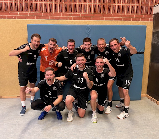 Handballherren stehen in einer Gruppe und jubeln über ihren Sieg