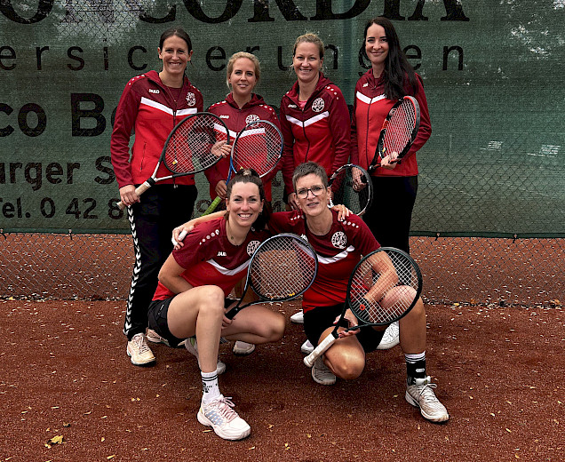 Tennisdamen in einer Gruppe mit Tennisschlägern auf dem Tennisplatz