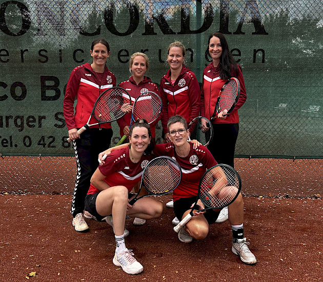 Tennisdamen in einer Gruppe mit Tennisschlägern auf dem Tennisplatz