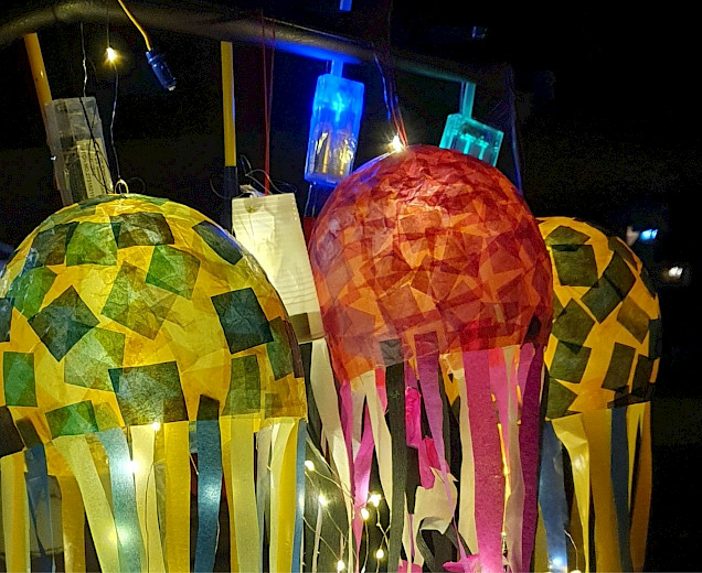 3 selbstgebastelte Laternen aus Papier, die aussehen wie bunte Quallen mit langen Armen