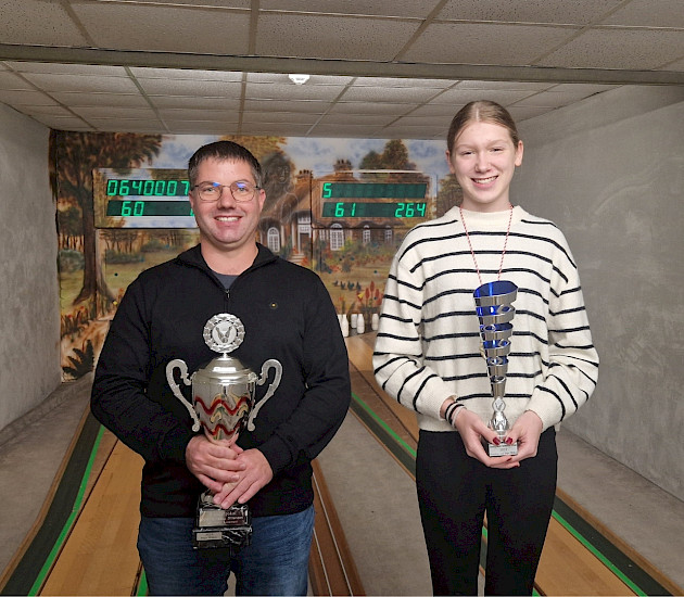 Ein Gewinner und eine Gewinnerin mit Pokalen beim Bowlen