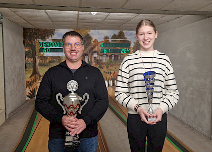 Ein Gewinner und eine Gewinnerin mit Pokalen beim Bowlen