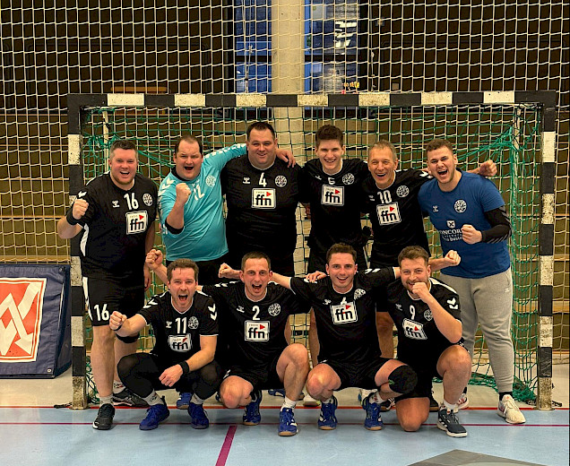 Handballherren stehen im Tor nach ihrem Sieg und jubeln