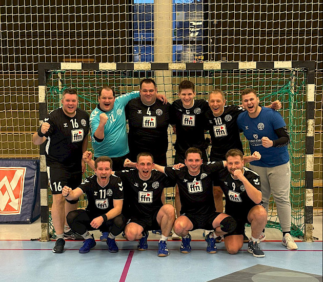 Handballherren stehen im Tor nach ihrem Sieg und jubeln