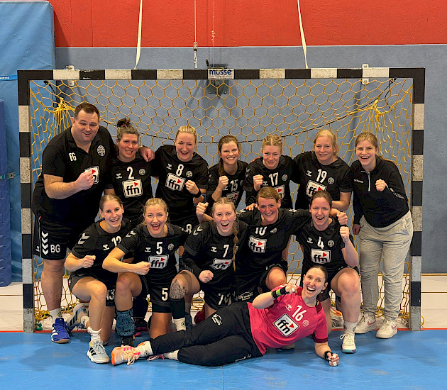 Handball-Damen-Team steht mit ihrem Trainer im Tor und bejubeln den Sieg Handball-Damen-Team steht mit ihrem Trainer im Tor und bejubeln den Sieg