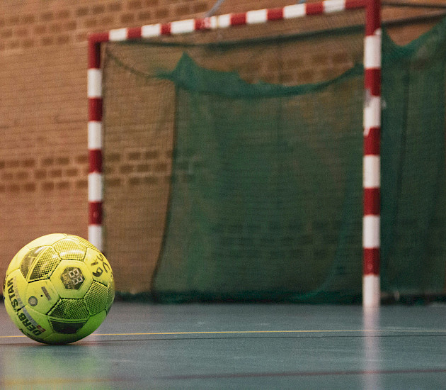 in der Halle liegt ein gelber Ball auf dem Boden vor dem Tor und ist ein Symbolbild für Handball