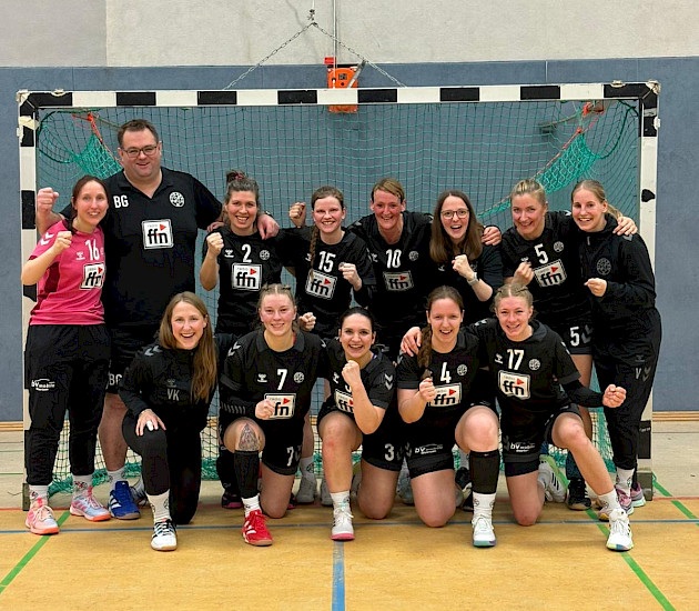 Handballdamen stehen mit ihrem Trainer im Tor der Tostedter Halle und freuen sich über ihren Sieg
