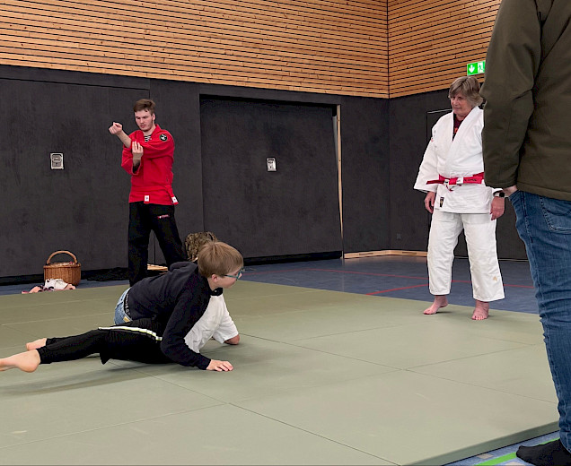 Die Judo-Lehrerin zeigt 2 Kindern ein paar Übungen Die Judo-Lehrerin zeigt 2 Kindern ein paar Übungen