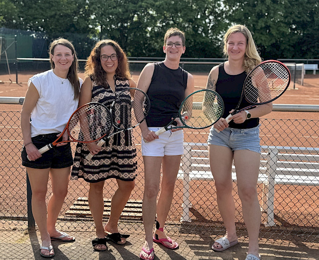 vier Tennisspielerinnen stehen nach dem Sieg fürbass Foto mit ihren Schlägern in der Hand vor dem Tennisplatz vier Tennisspielerinnen stehen nach dem Sieg fürbass Foto mit ihren Schlägern in der Hand vor dem Tennisplatz